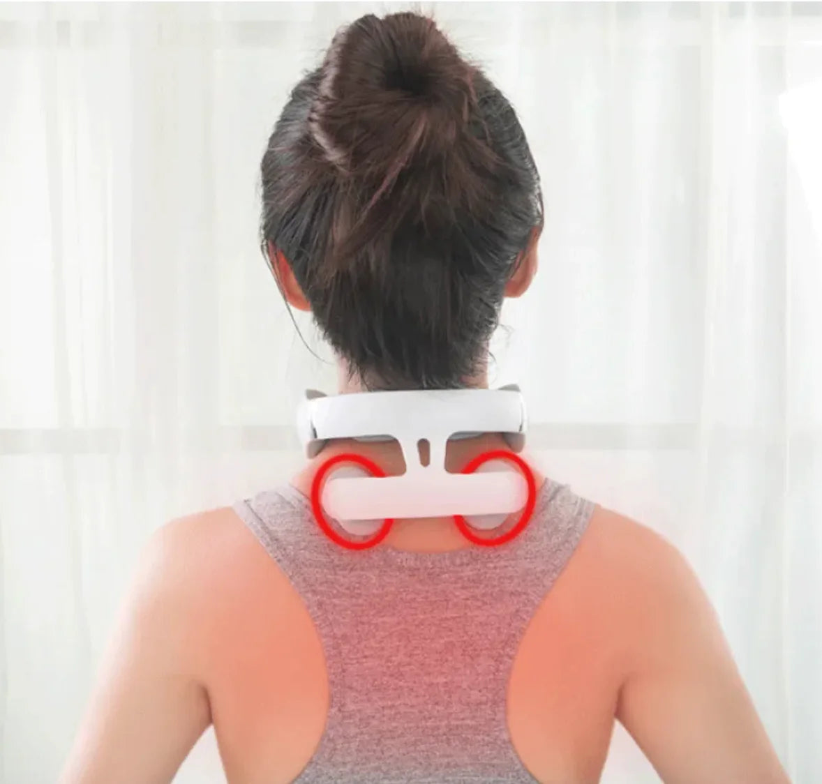 Person wearing a neck massager with a plain background
